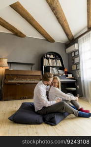 Happy and loving young couple sitting on the floor in the room