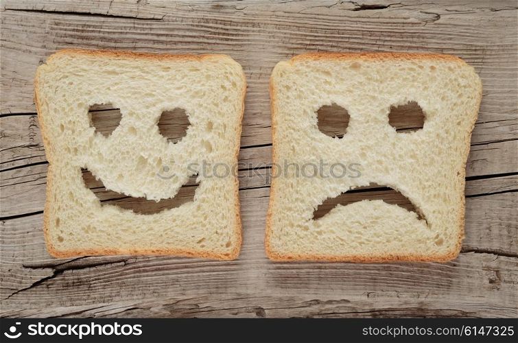 Happy and sad toast on a wooden board