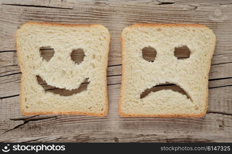 Happy and sad toast on a wooden board