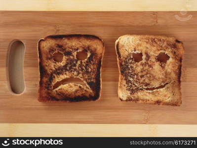 Happy and sad toast on a wooden cutting board