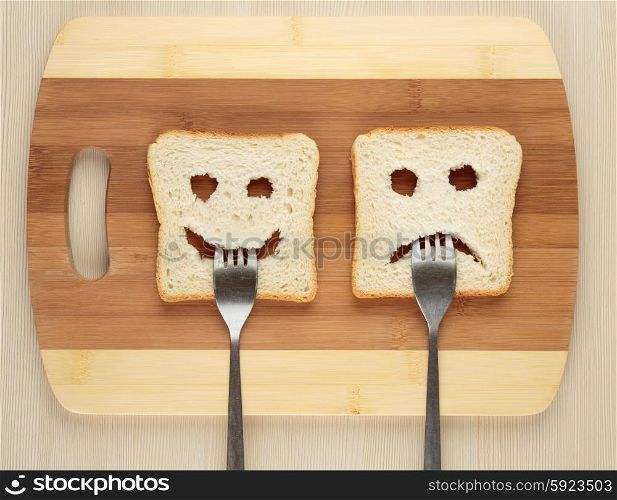 Happy and sad with a fork in her mouth on a cutting board