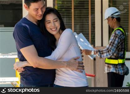 Happy and Smiling couple stand in front of constructor, handyman holding blueprint and checking details before renovations home, house improvement interior, Interior design, specialist concept