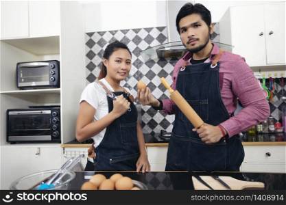 Happy and Smiling young couple cooking food in the kitchen at home