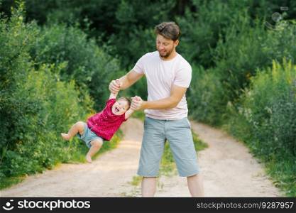 Happy and sweet moments of a summer walk in the park of a father and a little son