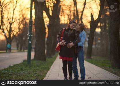 Happy and young pregnant couple have fun and relax outdoor