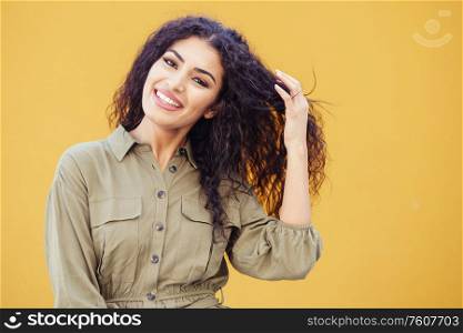 Happy Arab Woman with curly hair in urban background. Young Arab Woman with curly hair outdoors