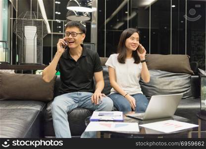 Happy Asian couple are working together and calling at night