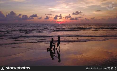 Happy Asian couple dating at the beach during travel honeymoon trip on holidays vacation outdoors. Ocean or nature sea at sunset, Phuket, Thailand