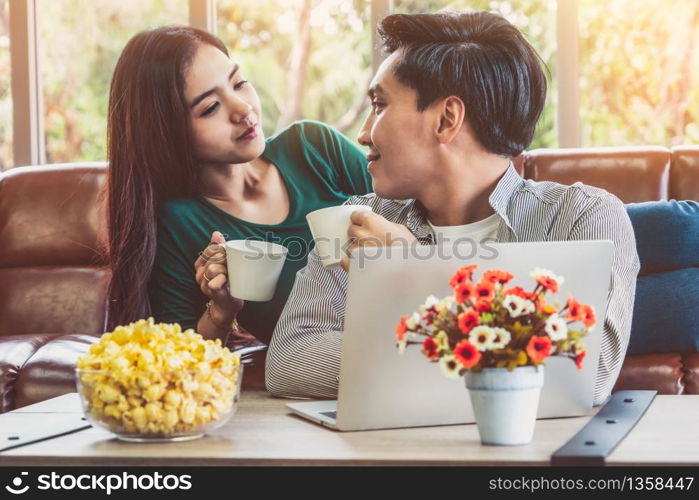 Happy Asian couple drink coffee at home. Love relationship and lifestyle concept.