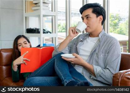 Happy Asian couple drink coffee at home. Love relationship and lifestyle concept.