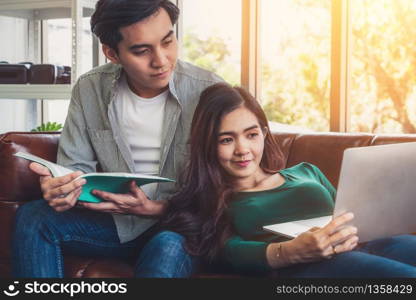 Happy Asian couple relax in living room. Love and relationship concept.