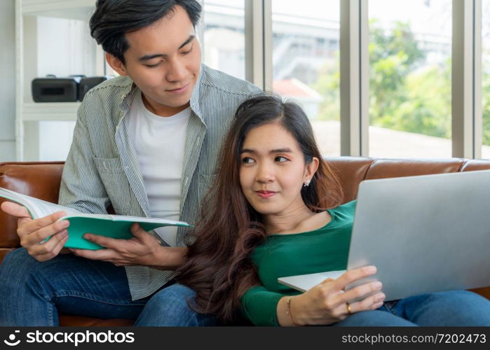 Happy Asian couple relax in living room. Love and relationship concept.