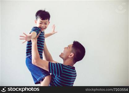 Happy Asian family with son at home and laughing