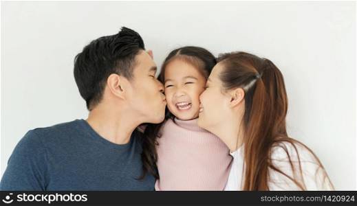 Happy Asian family. Young Father and Mother kiss in their daughter cheek together. Love emotion, Smiling face, Enjoying, Joyful.