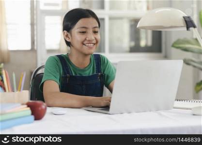 Happy asian girl learning online at home. Education and e-learning concept.