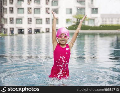 happy asian girl love swimming pool. Kid wearing pink swimming suite on water. Sport kid activities concept.
