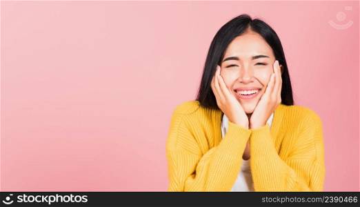 Happy Asian portrait beautiful cute young woman smile holding her cheeks looking to camera studio shot isolated on pink background Thai female beauty face touch massage healthy skin with copy space