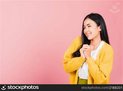 Happy Asian portrait beautiful cute young woman teen stand excited expression fist pressed together under chin pleased and delighted, thanking help studio shot isolated on pink background