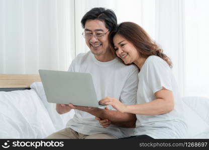 Happy Asian senior couple having good time at home. Old people retirement and healthy citizens elderly concept.