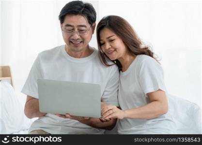 Happy Asian senior couple having good time at home. Old people retirement and healthy citizens elderly concept.
