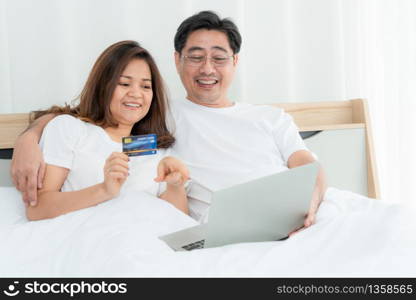 Happy Asian senior couple having good time at home. Old people retirement and healthy citizens elderly concept.