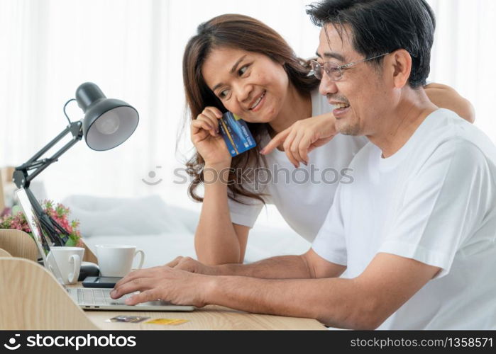 Happy Asian senior couple having good time at home. Old people retirement and healthy citizens elderly concept.