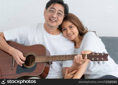 Happy Asian senior couple having good time at home. Old people retirement and healthy citizens elderly concept.