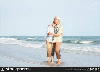 Happy Asian senior man and woman couple smile dancing resting relax on the beach honeymoon family sunny day, Romantic elderly enjoy travel summer vacation, plan life insurance at retirement couple