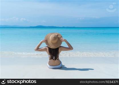 Happy Asian woman, a sexy Thai lady, relaxing and enjoying at turquoise sea near Phuket beach in summer during travel holidays vacation trip outdoors at natural ocean or island at noon, Thailand.