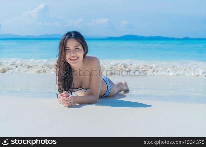 Happy Asian woman, a sexy Thai lady, relaxing and enjoying at turquoise sea near Phuket beach in summer during travel holidays vacation trip outdoors at natural ocean or island at noon, Thailand.