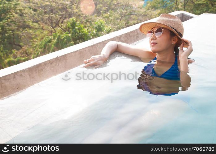 Happy asian woman enjoy swimming in the pool. Happy vacation