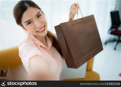 Happy asian woman taking selfie with shopping bag in the shop’s VIP lounge