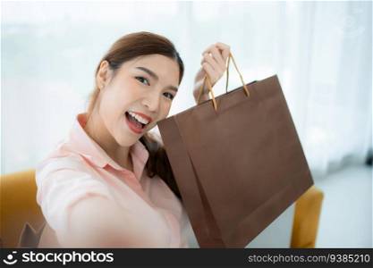 Happy asian woman taking selfie with shopping bag in the shop’s VIP lounge