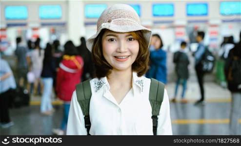 Happy Asian woman waiting the train at train station for travel in summer. Travel Thailand concept.