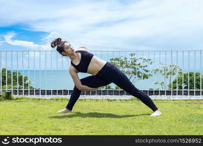 Happy Asian woman wearing black sport wear practice yoga Shoulder Opening Pose with beautiful sea view,Feeling relax and comfortable,Healthy Concept