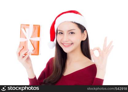 Happy asian woman with smile holding gift box of xmas, Present girl with celebration christmas, girl gesture ok isolated on white background, shopping with season concept.