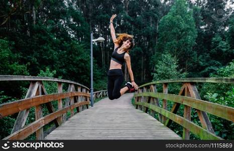 Happy athlete woman taking a leap outdoors