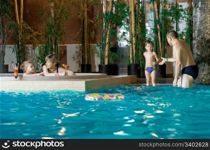 Happy attractive family relaxing by the pool