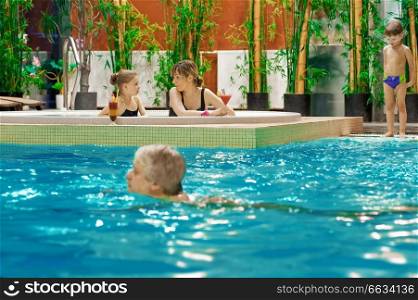 Happy attractive family relaxing by the pool.