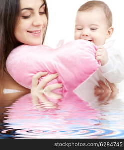 happy baby and mama with heart-shaped pillow in water