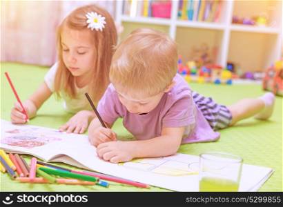 Happy baby boy & girl enjoying homework, preschool developing drawing skills, talented children learning art, kids back to school concept