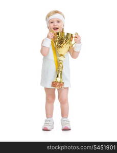 Happy baby in tennis clothes holding medal and goblet