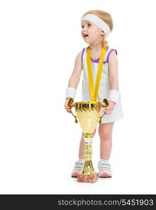 Happy baby in tennis clothes with medal and goblet looking on copy space