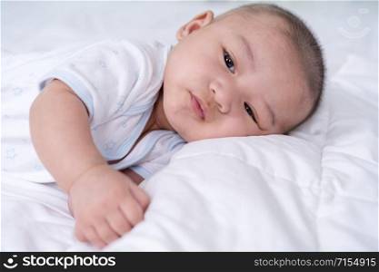 happy baby lying on a bed at home