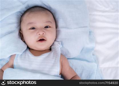 happy baby lying on a bed at home