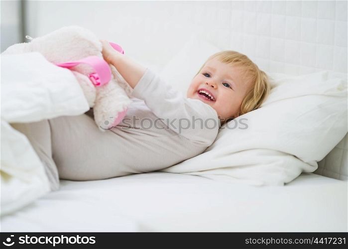 Happy baby playing in bed