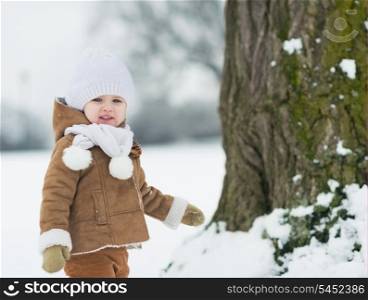 Happy baby playing outdoors in winter