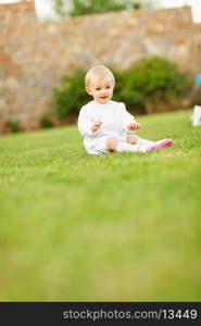 Happy baby sitting on grass