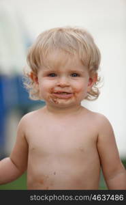 Happy baby with a dirty face after eat chocolate ice