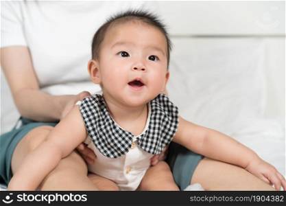 happy baby with mother on a bed at home